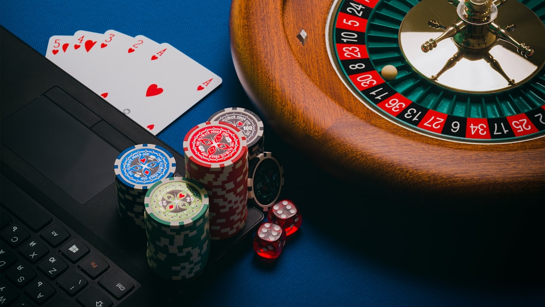 Roulette dan tumpukan chip warna-warni di atas meja kasino